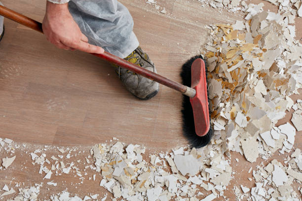 builder sweeping the floor after renovation